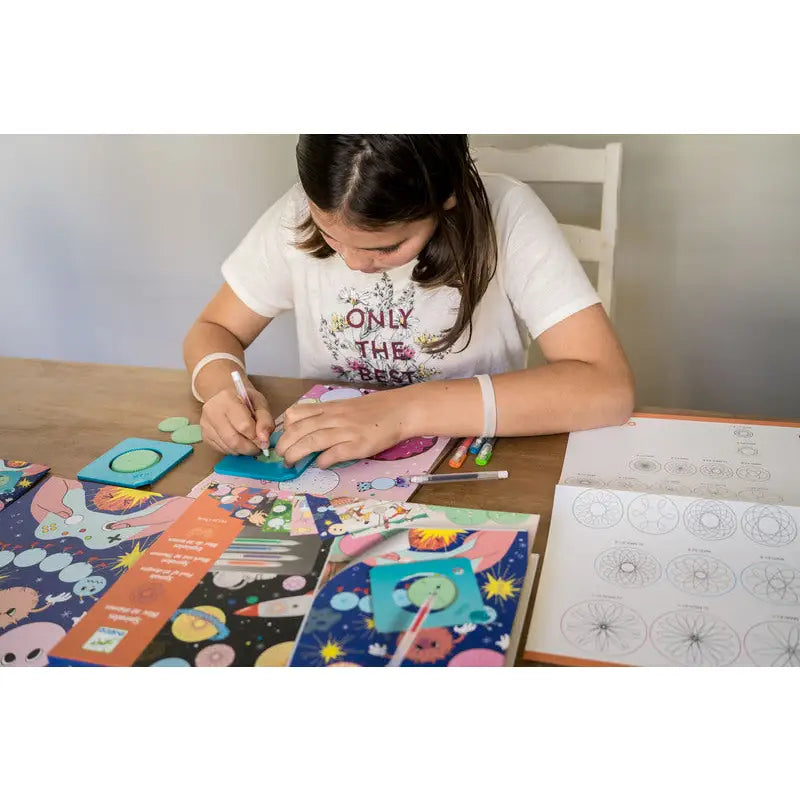 Young girl working on a colorful craft or art project at a table.