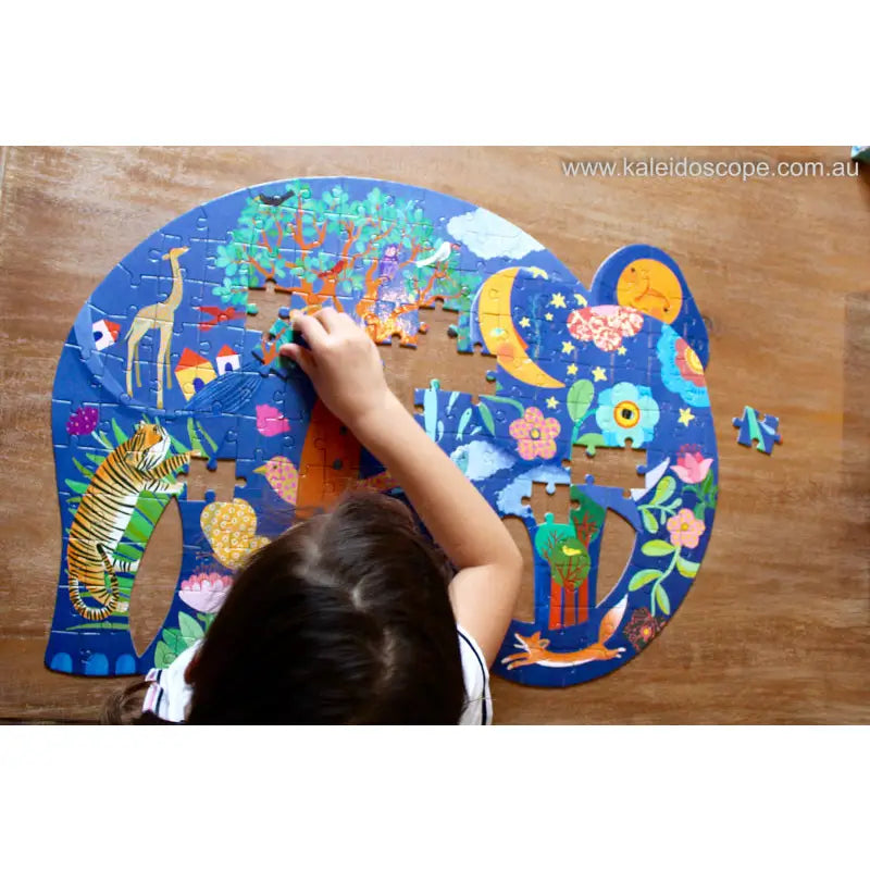 Colorful elephant-shaped jigsaw puzzle being assembled on a wooden surface.