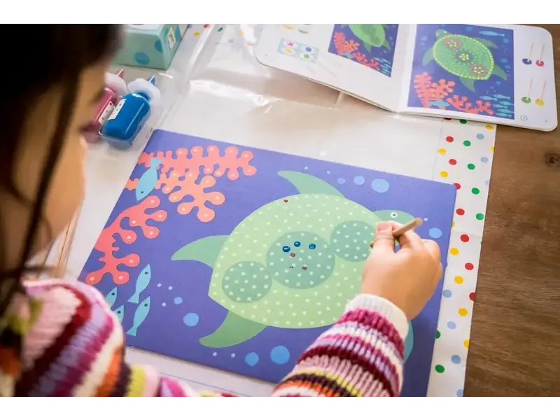 Colorful drawing of a smiling green fish with dots on its body.