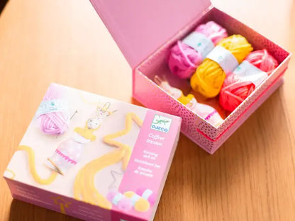 Pink box containing colorful balls of yarn or thread.