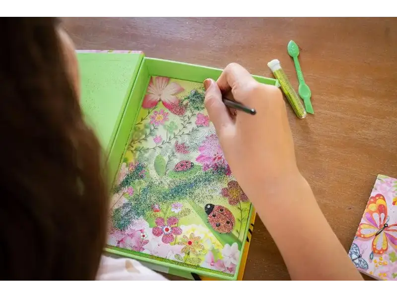 Green tray containing a colorful floral artwork being drawn or colored.