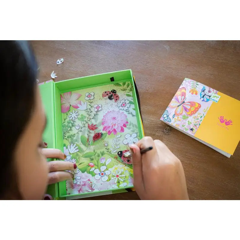 Colorful children’s book or notebook with floral designs being opened by small hands.