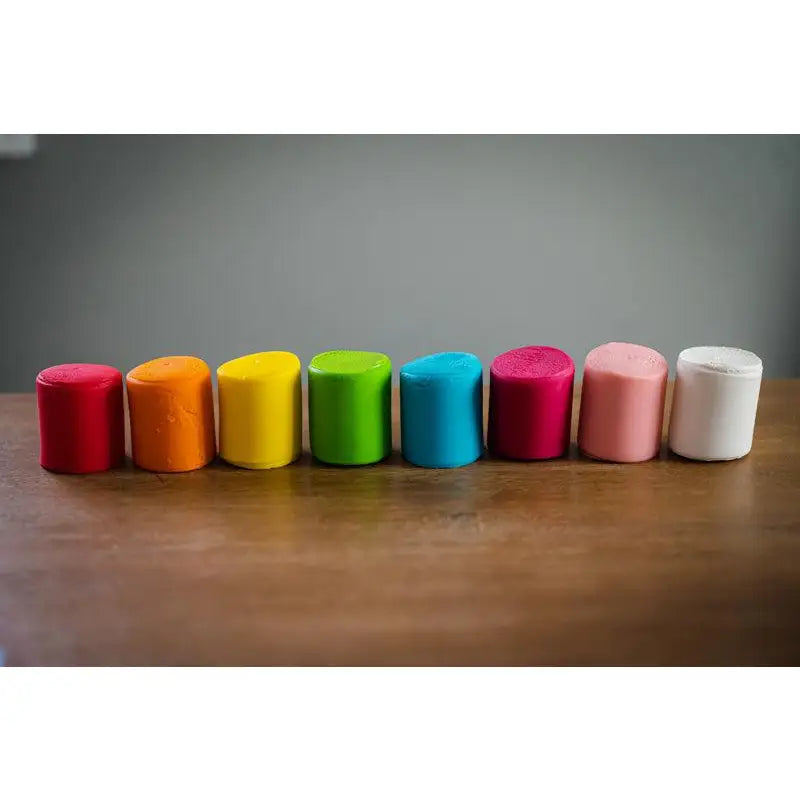 Row of colorful cylindrical objects arranged in a rainbow-like spectrum.