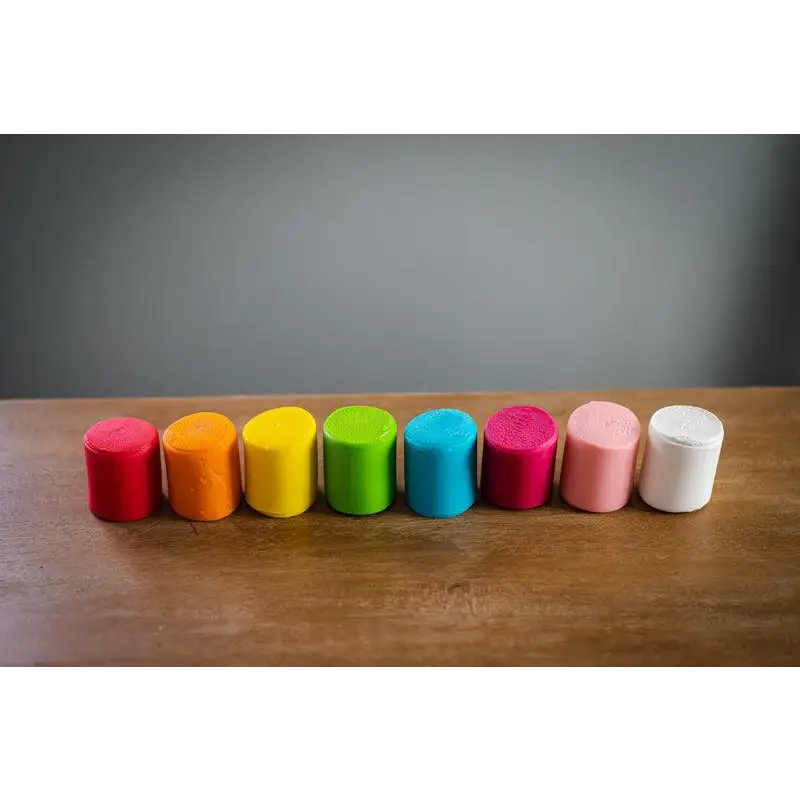 Row of colorful cylindrical objects arranged in a rainbow-like spectrum.