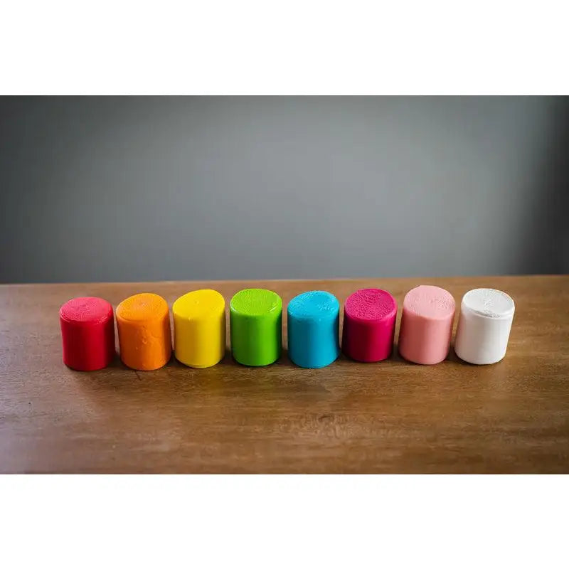 Row of colorful cylindrical objects arranged in a rainbow-like spectrum.