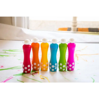 Colorful bowling pins with polka dot patterns arranged in a row.