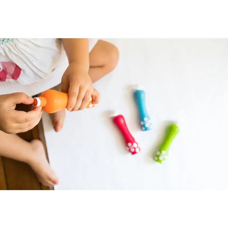 Colorful plastic toy bowling pins scattered on a white surface.