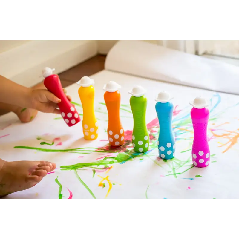 Colorful plastic bottles filled with paint arranged in a rainbow spectrum.