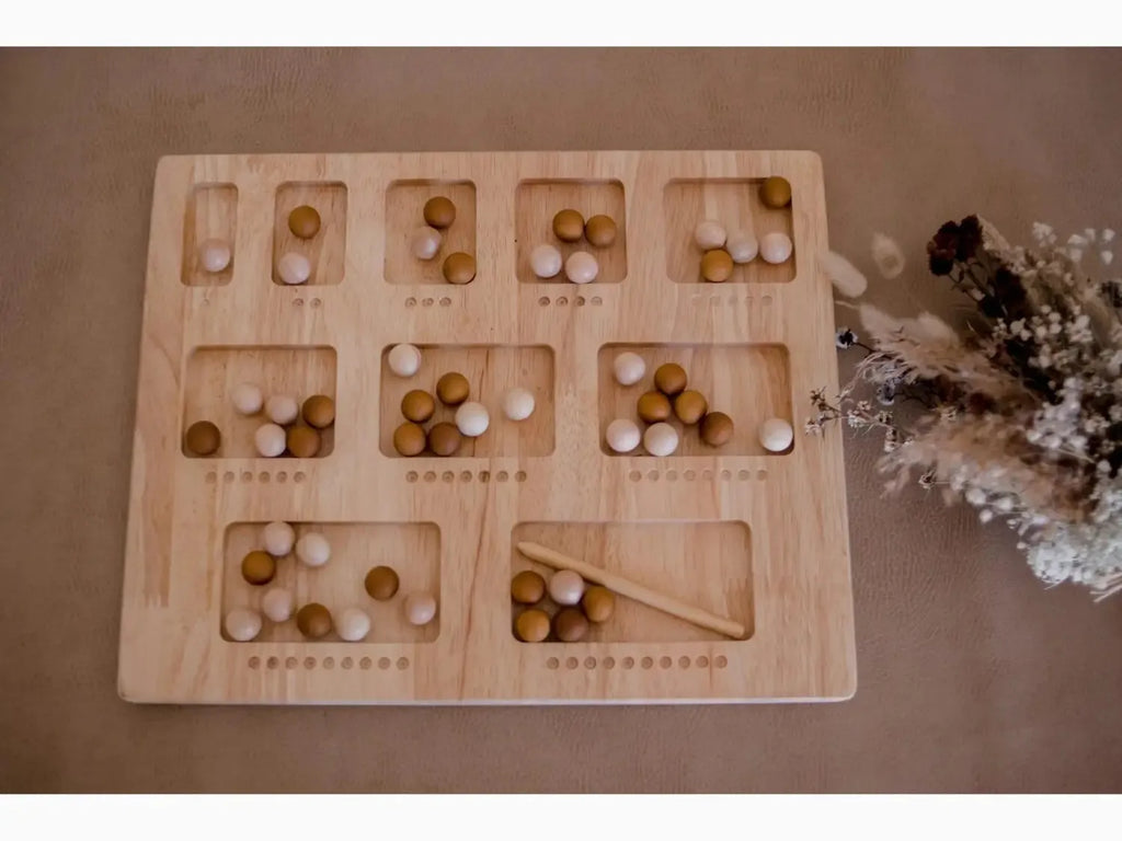 Wooden counting board with numbered compartments containing white and brown balls.