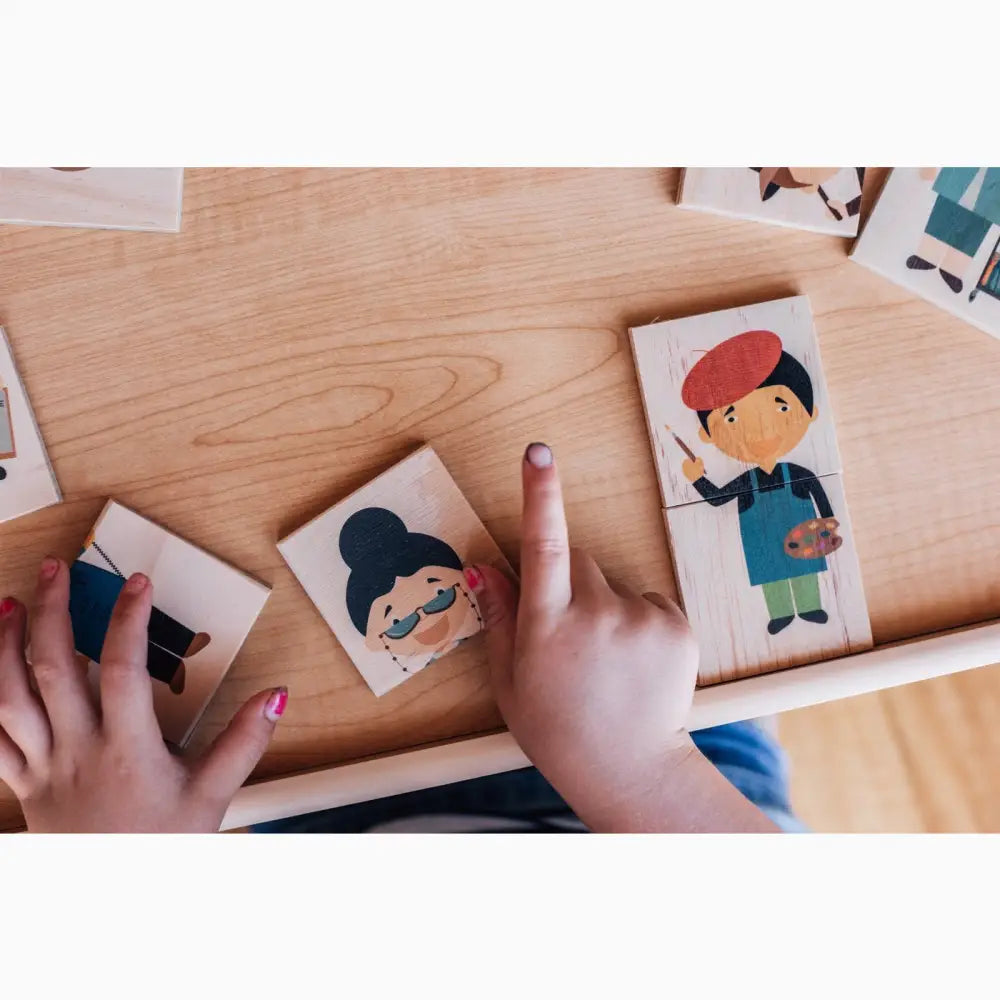 Hands arranging cartoon character cards on a wooden surface.