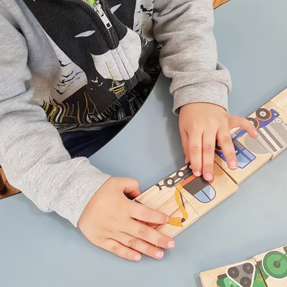 Wooden puzzle with colorful shapes and numbers being manipulated by small hands.