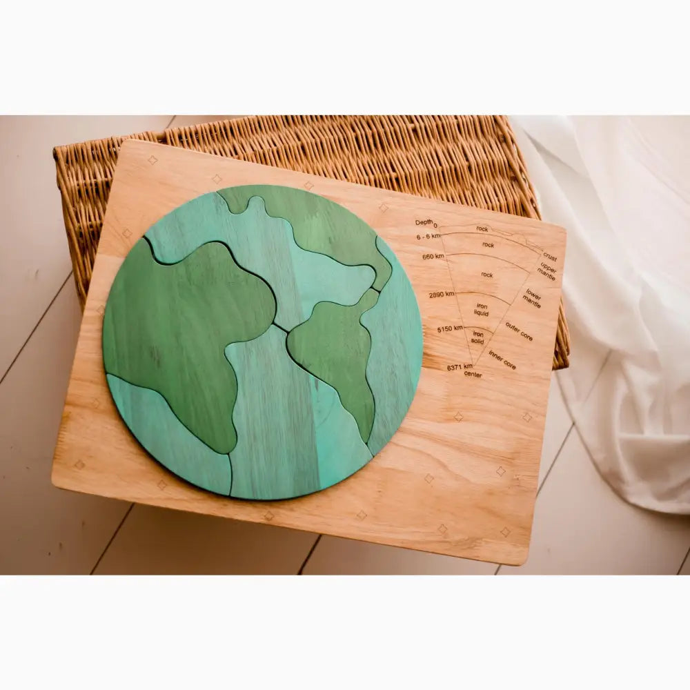 Wooden puzzle map of Earth with green and blue continents and oceans.