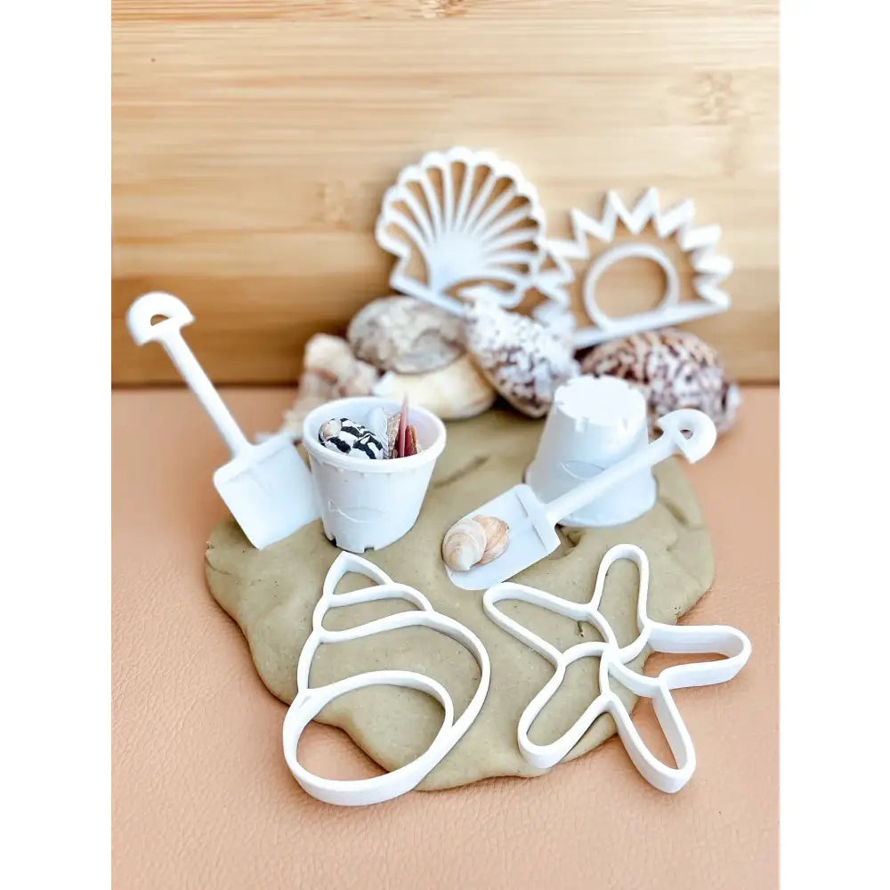 Clay or dough with various beach-themed cookie cutters and decorative elements.
