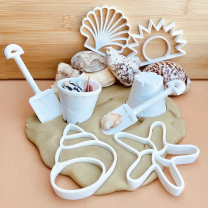 Beach-themed play dough set with shells and plastic molds for sand castle shapes.
