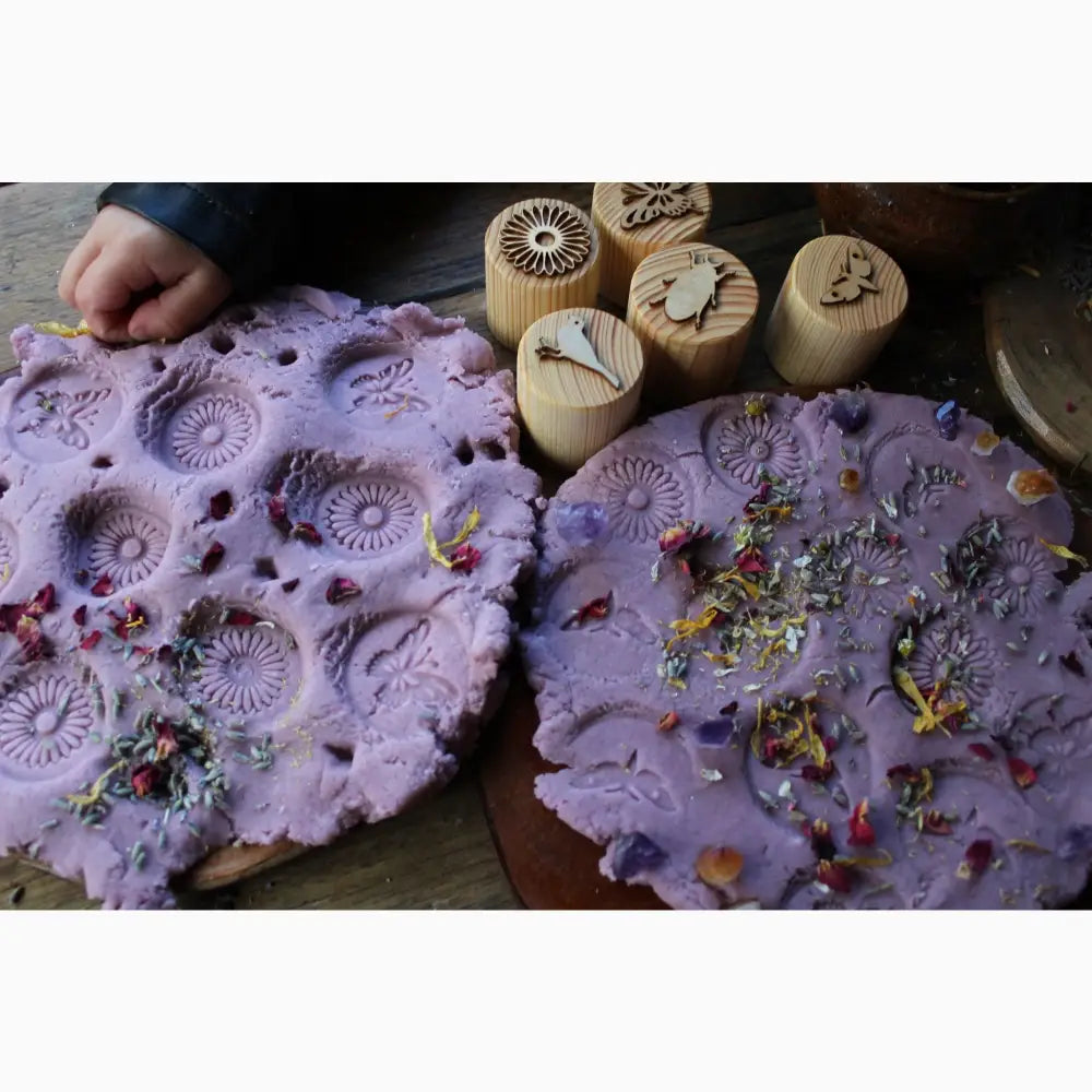 Purple clay slabs with imprinted patterns and embedded flower petals.