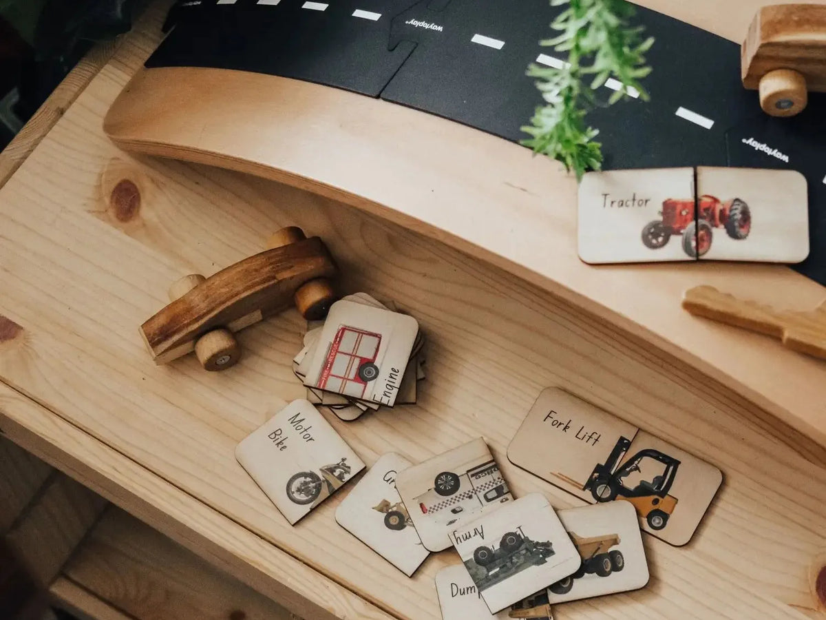 Wooden toy road or track system with miniature vehicles and accessories.
