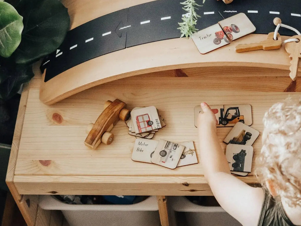 Wooden toy car ramp or track with a painted road surface.