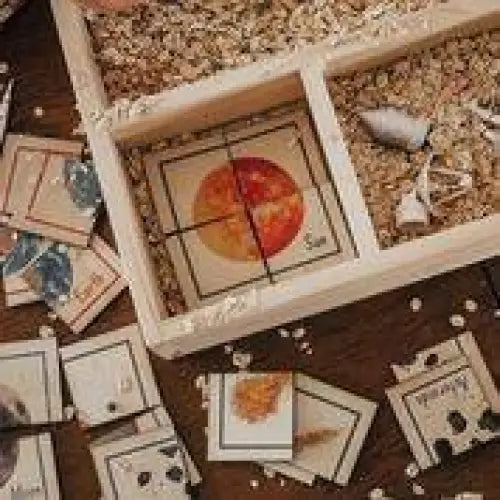 Wooden box with compartments containing various small objects and images.