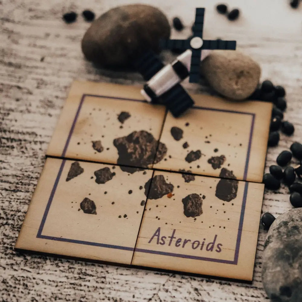 Tile or card labeled ’Asteroids’ with small rocks scattered on its surface.