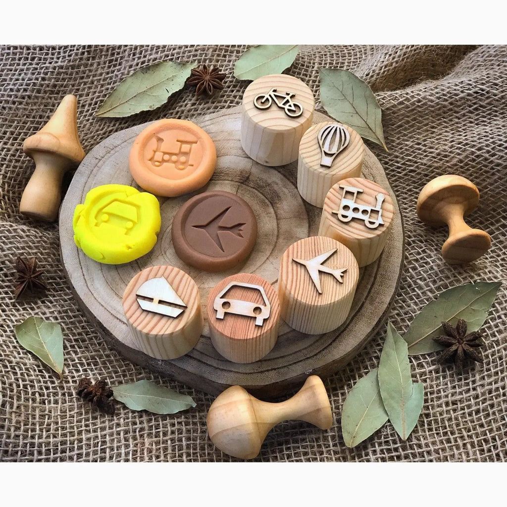 Wooden stamps with various transportation-themed icons imprinted on their surfaces.