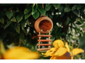 Wooden birdhouse with a circular entrance and ladder-like perch.