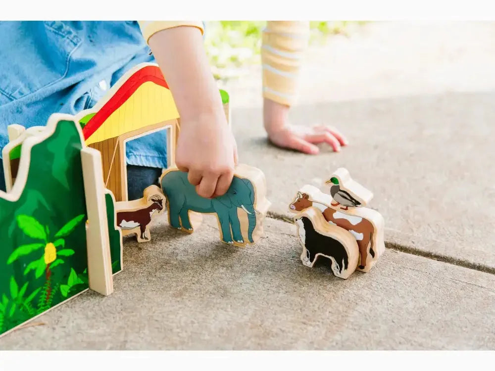 Colorful wooden toy farm set with animals and a barn-like structure.