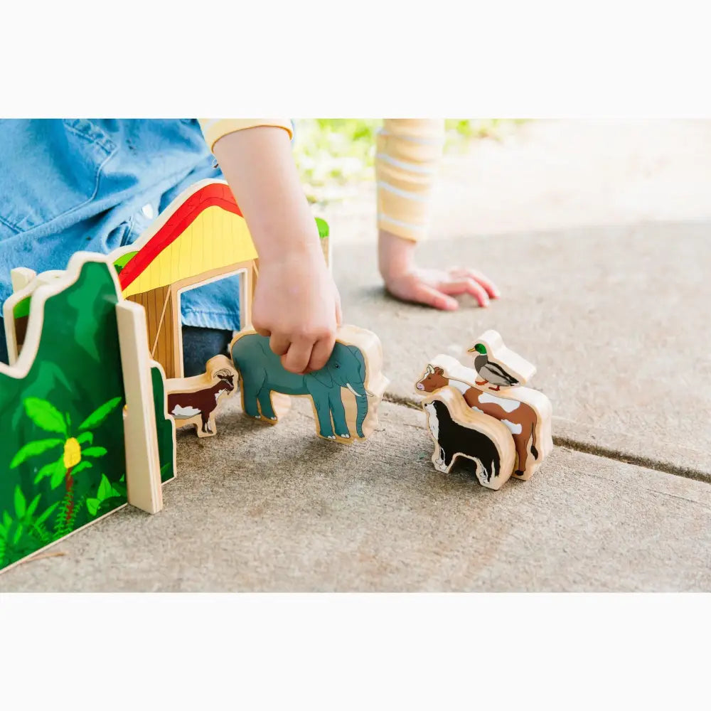 Colorful wooden toy farm set with animals and a barn-like structure.