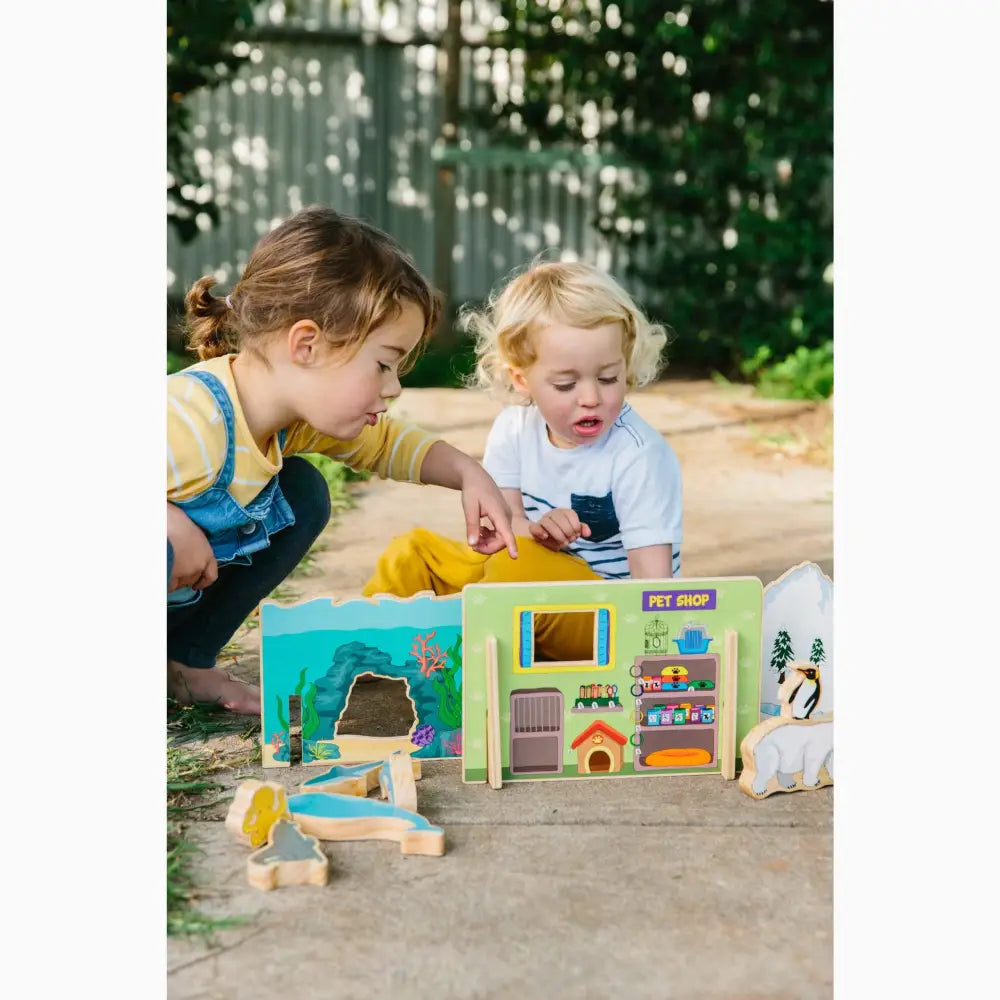 Colorful toy dollhouse or playhouse with multiple rooms and accessories.