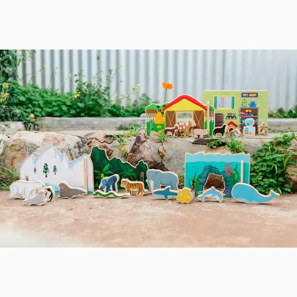 Colorful wooden toy set featuring various animals and habitats, including an igloo, forest, and underwater scenes.