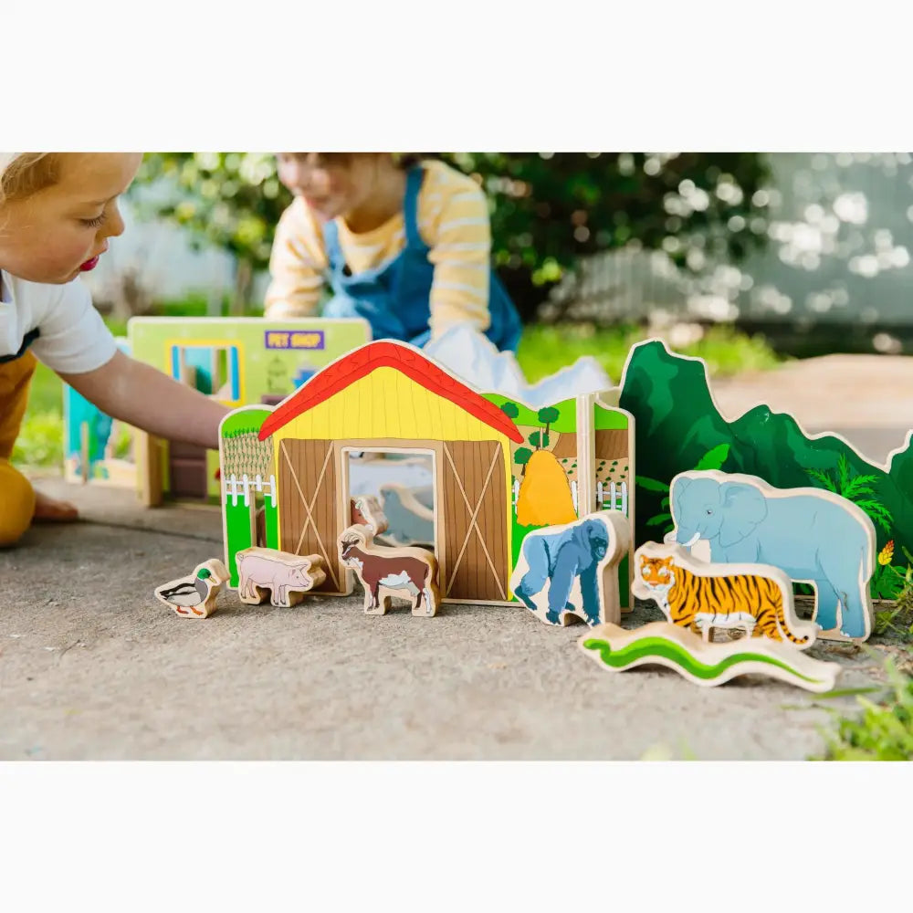 Colorful wooden toy farm set with animals and a barn.