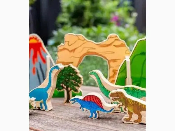 Colorful wooden dinosaur figurines and a tree on a wooden surface.