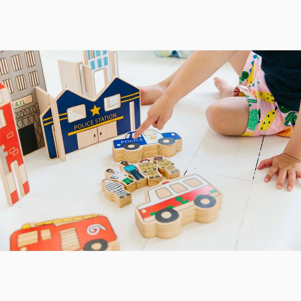 Wooden toy set featuring buildings, vehicles, and puzzle pieces for imaginative play.