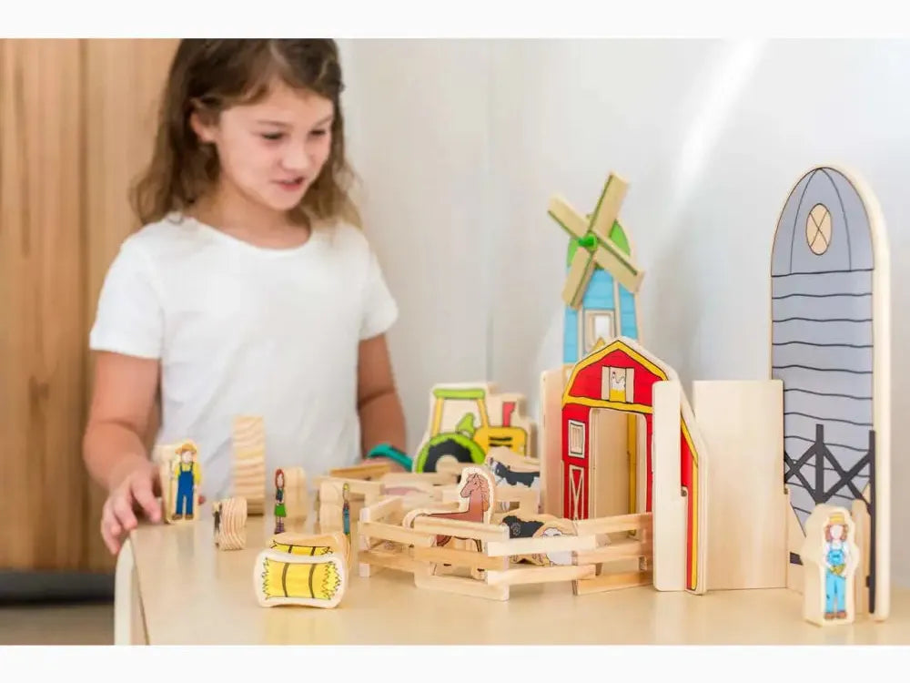 Wooden farm playset with colorful buildings, animals, and figures.
