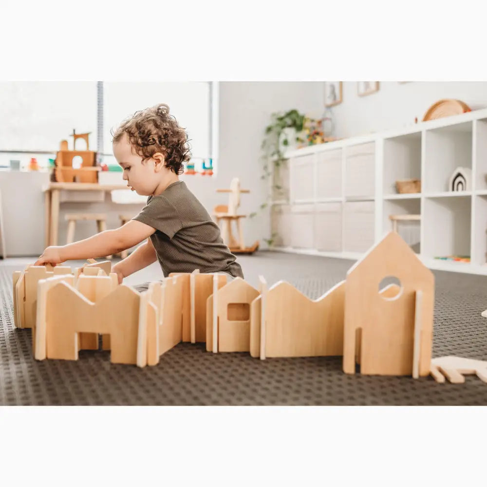 Wooden building blocks or construction toys arranged on the floor.