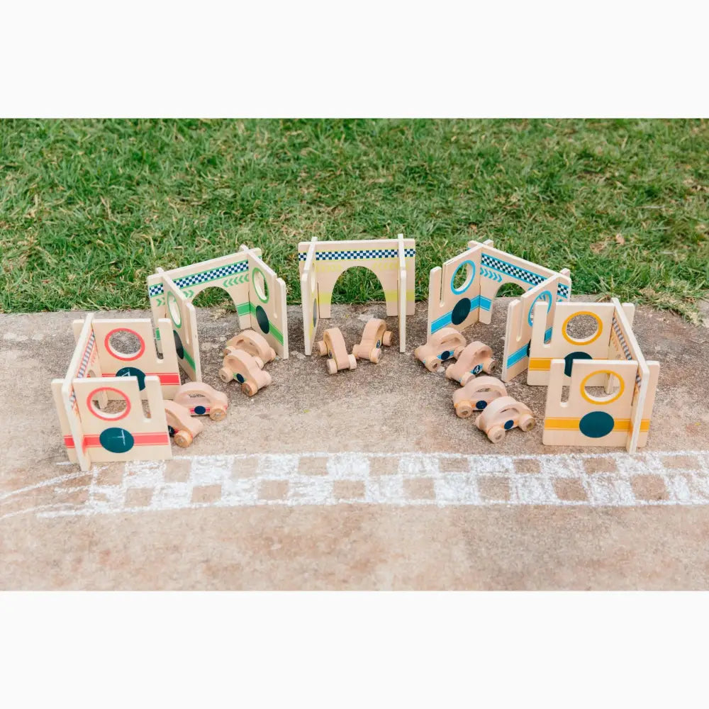 Wooden toy train set with colorful arches and blocks on a concrete surface.