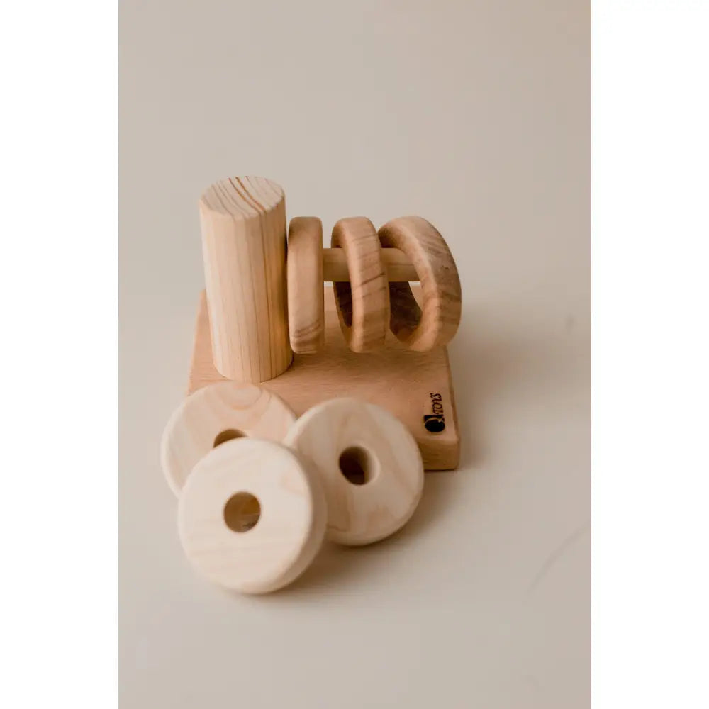 Wooden toy or puzzle piece shaped like the word ’no’ alongside circular wooden elements.