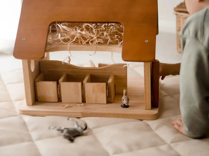 Wooden toy barn or stable with compartments and a hay loft.