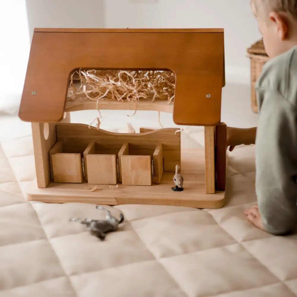 Wooden toy barn or stable with compartments and a hay loft.