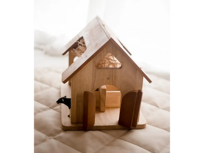 Wooden dollhouse or miniature house with a peaked roof and open doorway.