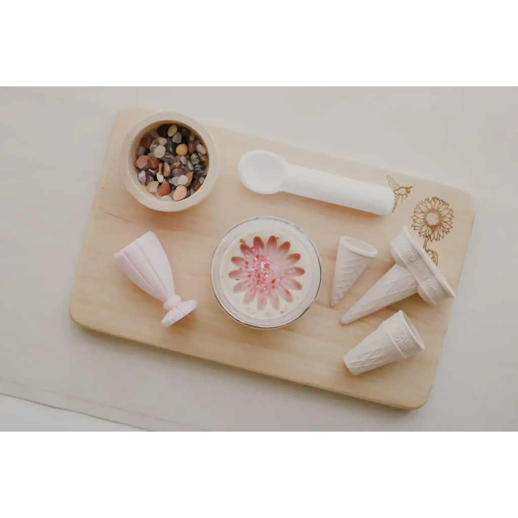 Wooden cutting board or serving tray with various white ceramic items and a pink floral dish.