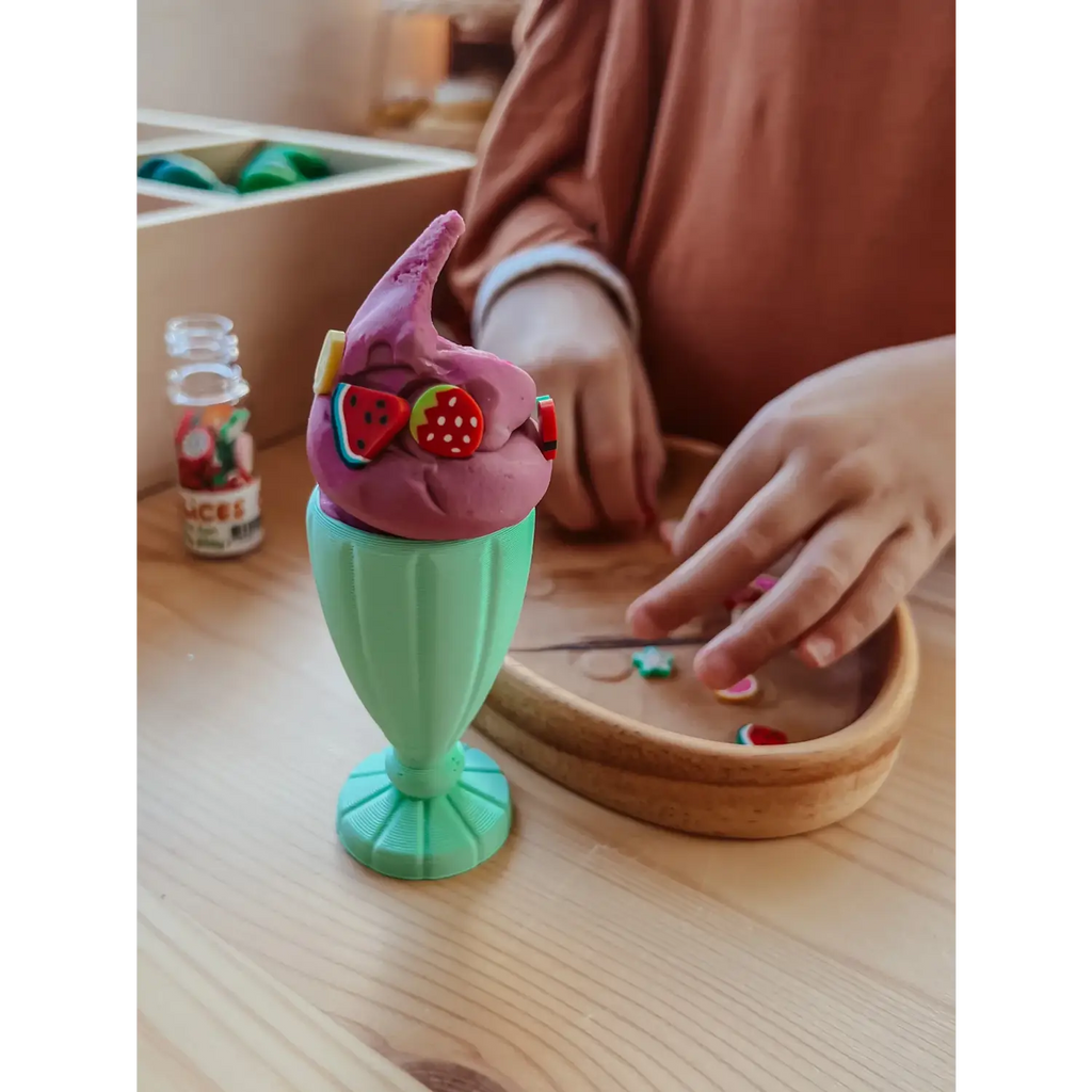 Colorful plastic ice cream sundae toy with a pink top and green base.