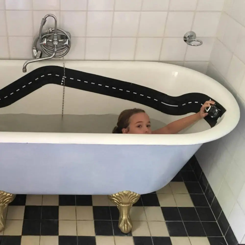 Clawfoot bathtub with a painted black road design on its side.