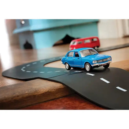 Blue toy car on a miniature road.