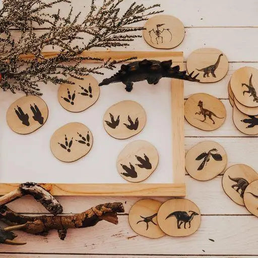 Collection of wooden discs with dinosaur silhouettes engraved on them.