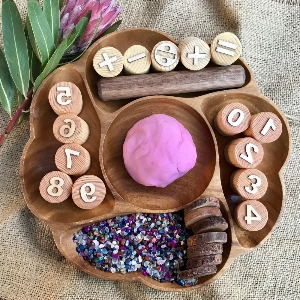 Wooden tray with compartments containing playdough, glitter, and numbered wooden discs.