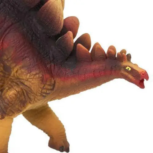 Plastic toy dinosaur with rows of plates along its back and a reddish head.