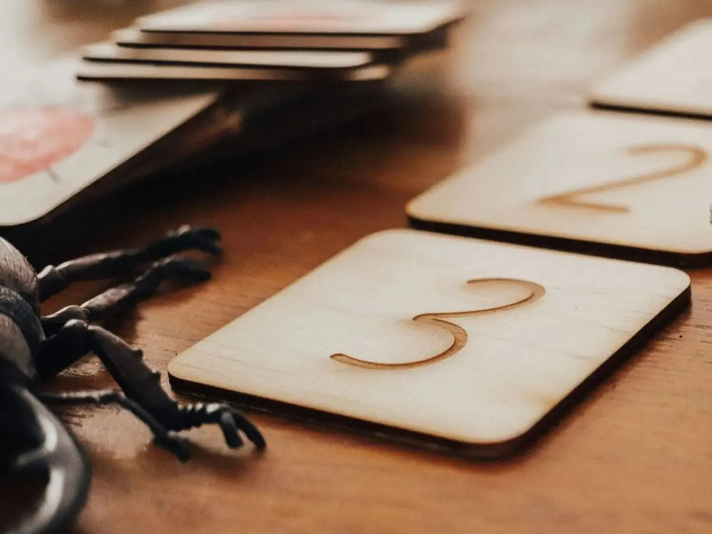 Wooden square tile with the number 3 engraved on it.