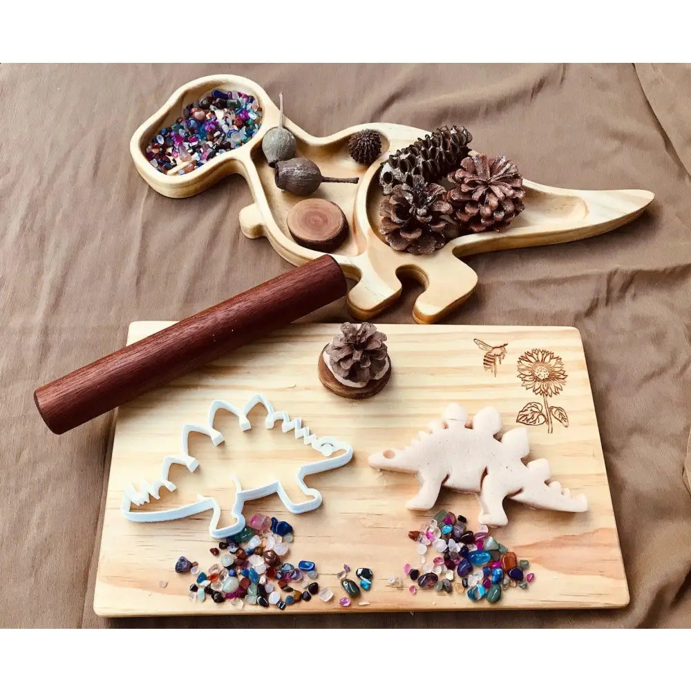 Wooden dinosaur-shaped craft board with compartments for beads and decorations.