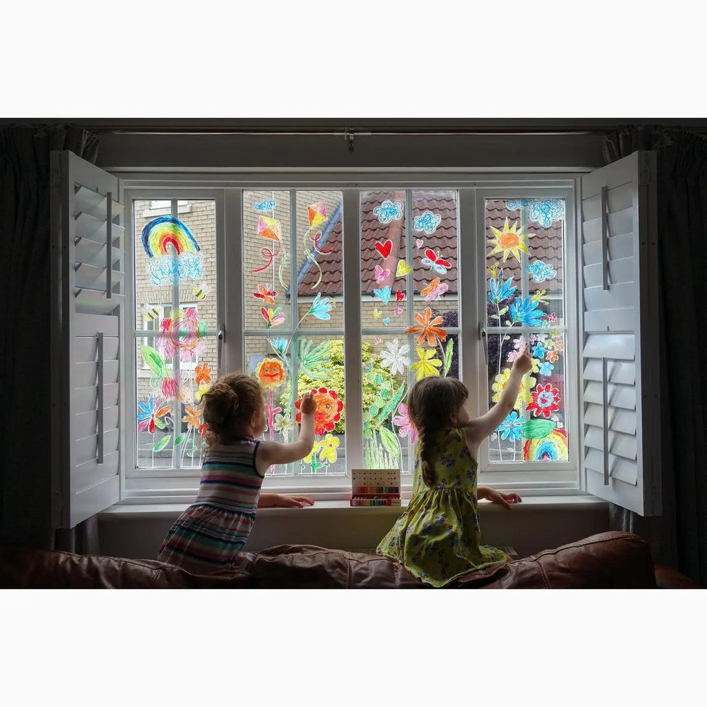 Window decorated with colorful children’s paintings and drawings.