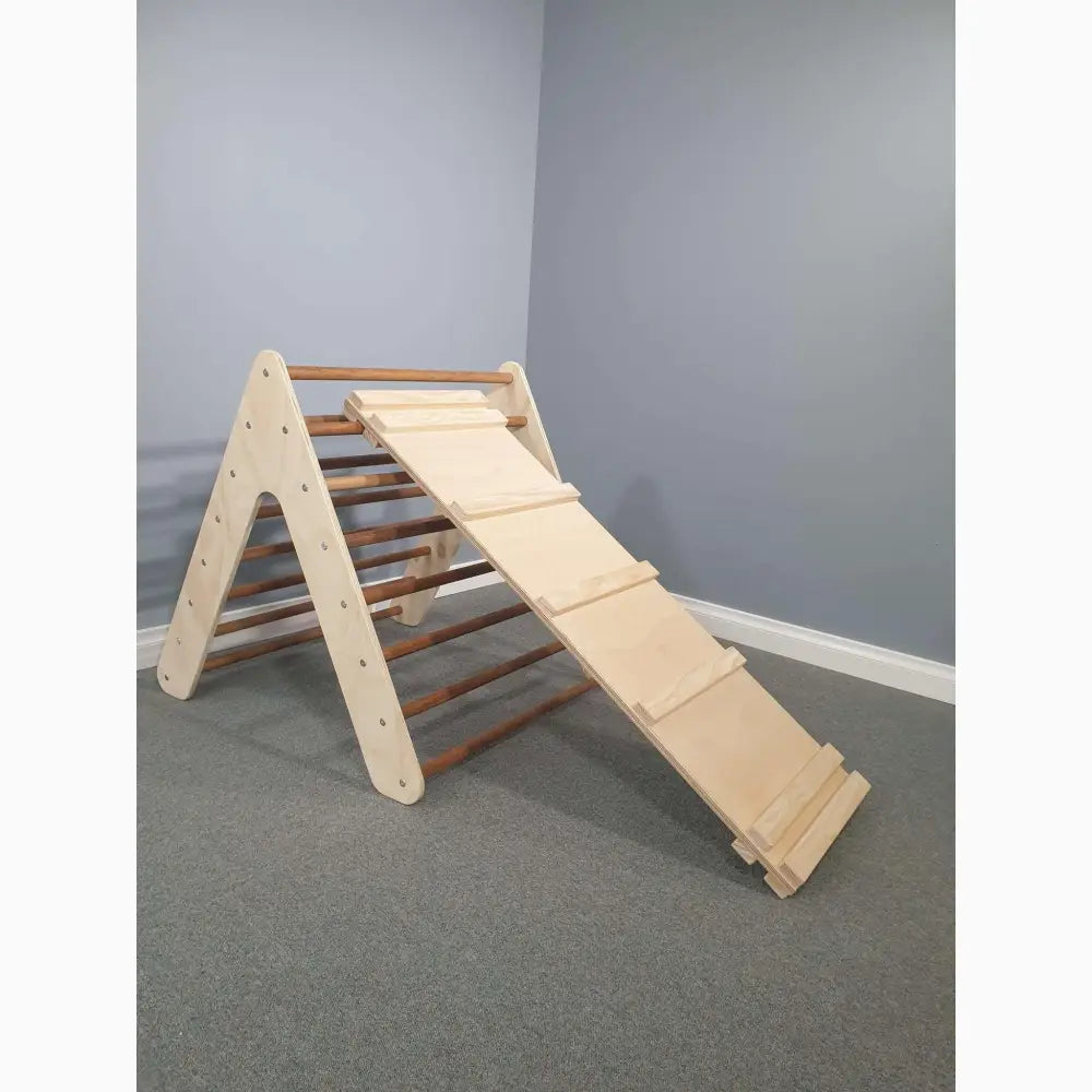 Wooden climbing triangle with attached ramp for children’s play.